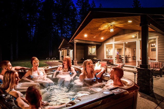 Friends or couples socialising in hot tub at night