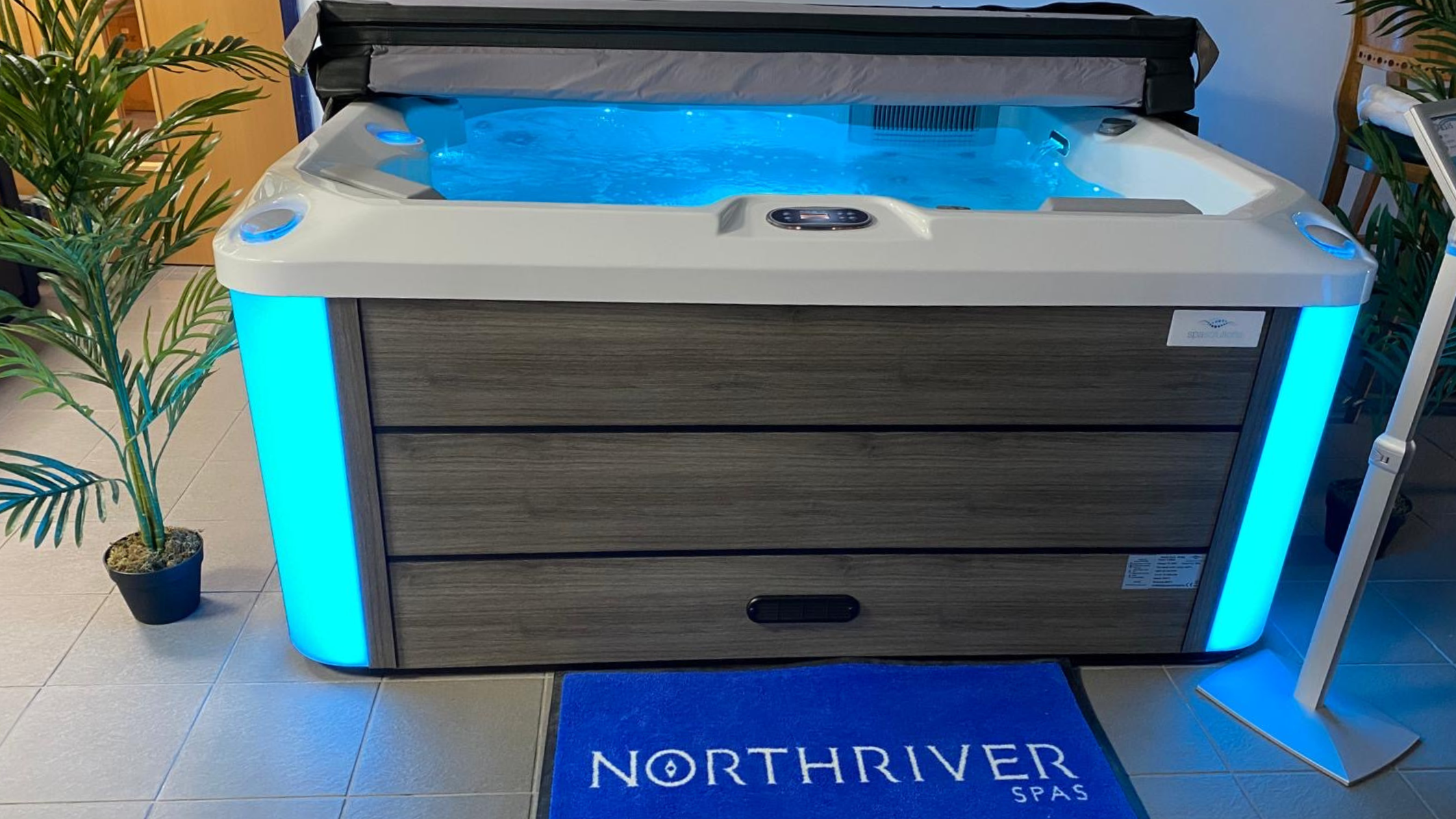 Oasis by North River Spas surrounded by plants in Aqua Living showroom, Kettering